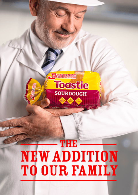 Johnston Mooney & O'Brien Baker holding a new Toastie Sourdough loaf of bread